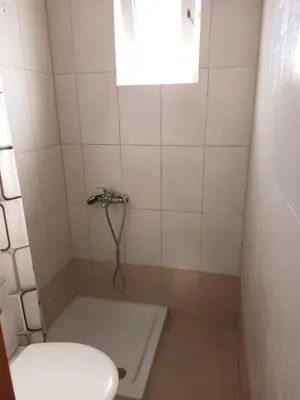 a bathroom with a shower with a toilet and a window at IRINIS HOUSES in Rhodes Town
