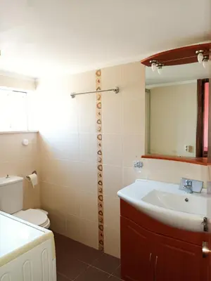 a bathroom with a sink and a toilet and a mirror at IRINIS HOUSES in Rhodes Town