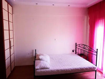 a bedroom with a bed with pink walls and a window at IRINIS HOUSES in Rhodes Town