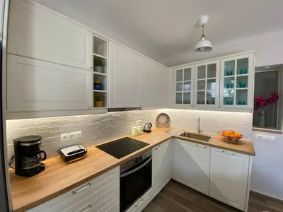 a kitchen with white cabinets and a wooden counter top at Filoxenia Apartment in Asgourou