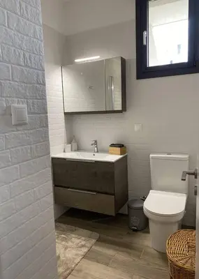 a bathroom with a sink and a toilet and a mirror at Filoxenia Apartment in Asgourou
