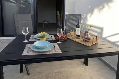 a table with a plate of food and wine glasses at Filoxenia Apartment in Asgourou