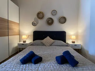a bedroom with a bed with blue pillows on it at Filoxenia Apartment in Asgourou
