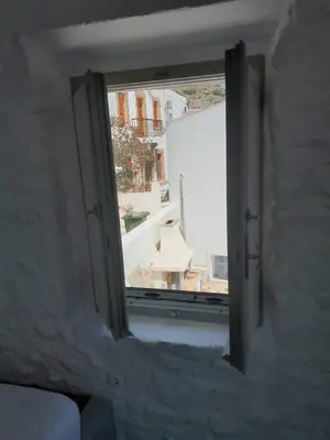 an open window with a view of a building at Oniropagida Nisyros apartments #2 Nikia view in Nikiá