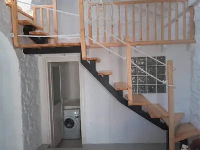 a staircase in a house with a washing machine at Oniropagida Nisyros apartments #2 Nikia view in Nikiá