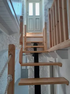 a wooden staircase in a house with a door at Oniropagida Nisyros apartments #2 Nikia view in Nikiá