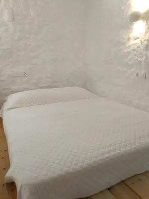 a white bed in a room with a white wall at Oniropagida Nisyros apartments #2 Nikia view in Nikiá