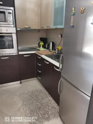 a kitchen with stainless steel appliances and brown cabinets at Stella Luxury Apartment Kalathos in Kalathos