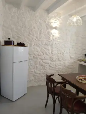 a kitchen with a white refrigerator and a table at Oniropagida Nisyros apartment #1 in Nikiá