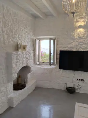 a white room with a flat screen tv on a wall at Oniropagida Nisyros apartment #1 in Nikiá