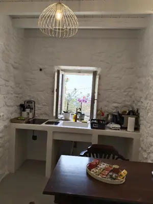 a kitchen with a counter and a window and a table at Oniropagida Nisyros apartment #1 in Nikiá