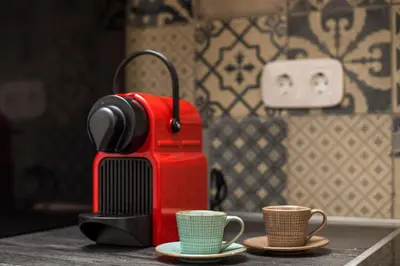 a red coffee maker and two cups on a counter at Traditional Loft Casa Di Vini in Kalithies