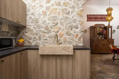 a kitchen with a sink and a stone wall at Traditional Loft Casa Di Vini in Kalithies