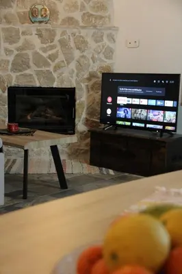 a living room with a fireplace and a television at Traditional Loft Casa Di Vini in Kalithies