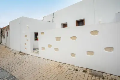 a white wall with drawings on it on a street at Traditional Loft Casa Di Vini in Kalithies