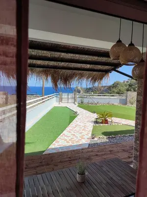 an open patio with a view of a lawn at Kalokairini Avra in Archangelos