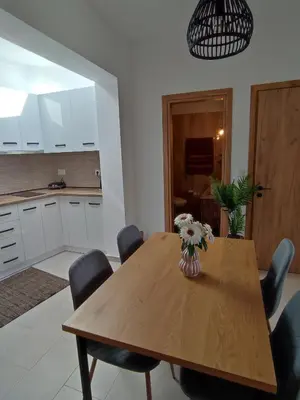 a dining room table with chairs and a vase of flowers on it at Kalokairini Avra in Archangelos