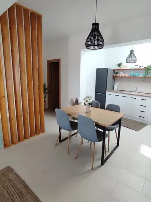 a dining room with a table and chairs and a kitchen at Kalokairini Avra in Archangelos