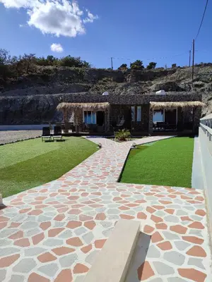 a stone walkway with a bench in front of a house at Kalokairini Avra in Archangelos