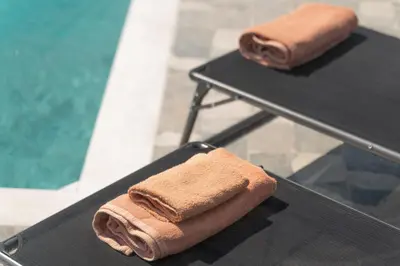 two brown towels are sitting on two tables at Propodes Luxury Villa in Pastida