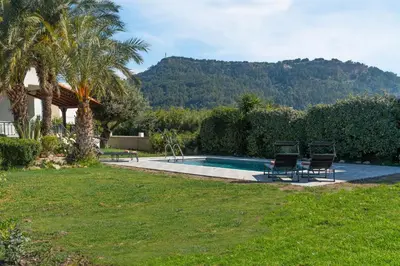 a swimming pool with two chairs in a yard at Propodes Luxury Villa in Pastida