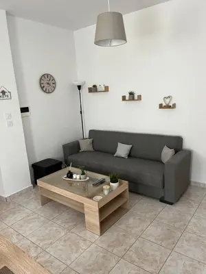 a living room with a couch and a coffee table at G.S Ialysos Holiday Apartment in Ialyssos