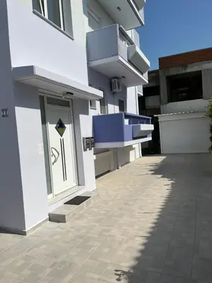 a side view of a white building with a patio at G.S Ialysos Holiday Apartment in Ialyssos