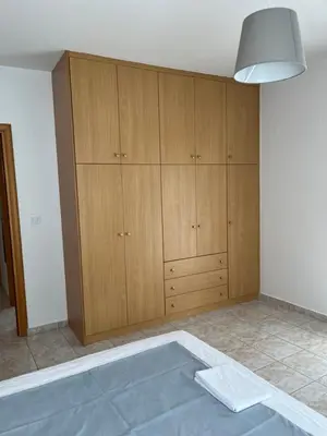 a room with wooden cabinets and a tub at G.S Ialysos Holiday Apartment in Ialyssos