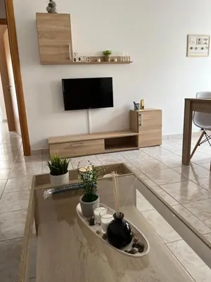 a living room with a tv and a table at G.S Ialysos Holiday Apartment in Ialyssos