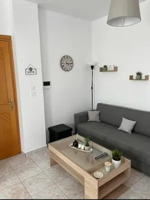 a living room with a couch and a coffee table at G.S Ialysos Holiday Apartment in Ialyssos