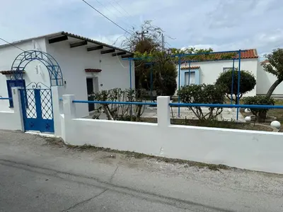 a white fence with a blue gate in front of a house at Blue and White in Kremasti