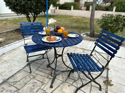 a blue table with a plate of food and two chairs at Blue and White in Kremasti