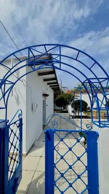 a blue metal gate in front of a building at Blue and White in Kremasti