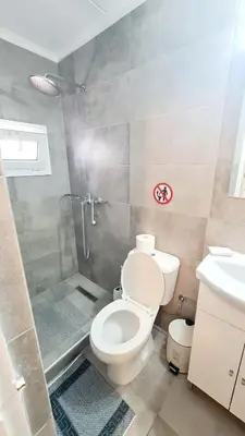 a bathroom with a toilet and a shower and a sink at Blue and White in Kremasti