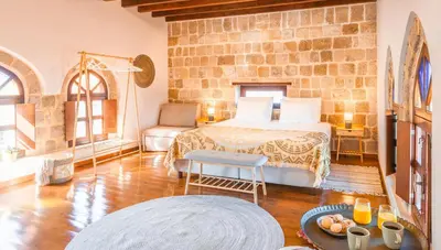 a bedroom with a bed and a stone wall at Mandorla Apartments in Rhodes Town