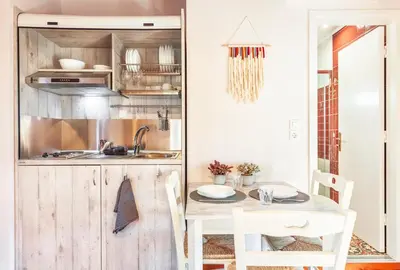 a small kitchen with a table and a sink at Mandorla Apartments in Rhodes Town
