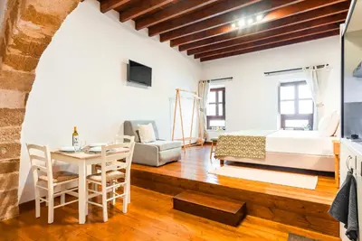 a living room with a bed and a table and chairs at Mandorla Apartments in Rhodes Town