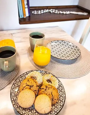 a table with two plates of biscuits and orange juice at Mandorla Apartments in Rhodes Town