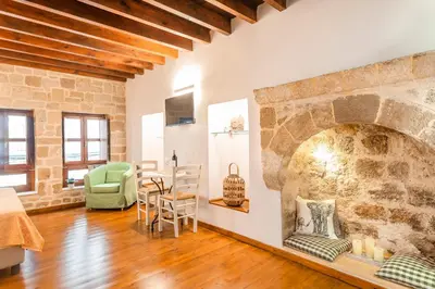 a living room with a large stone fireplace at Mandorla Apartments in Rhodes Town