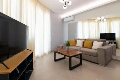 a living room with a couch and a table at Tsatos Luxury Residence in Kremasti