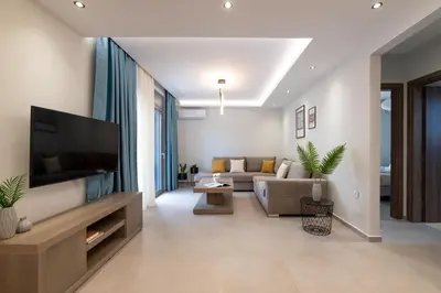 a living room with a couch and a flat screen tv at Tsatos Luxury Residence in Kremasti