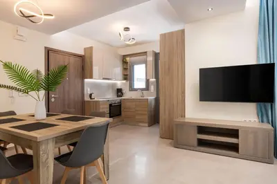 a kitchen and dining room with a table and a television at Tsatos Luxury Residence in Kremasti