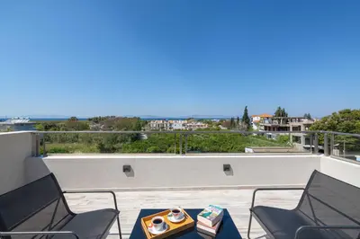 a table and chairs on a balcony with a view at Tsatos Luxury Residence in Kremasti