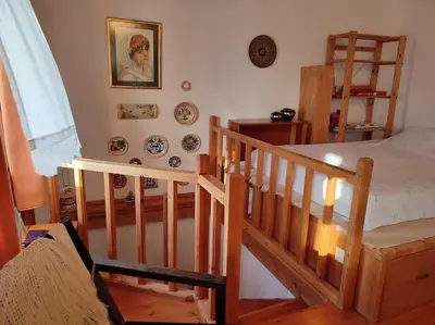 a bedroom with a bed and a staircase with plates on the wall at Omorfo House in Asklipiḯon