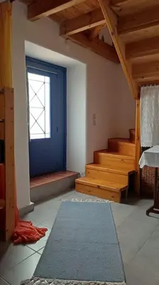 a room with a blue door and stairs with a rug at Omorfo House in Asklipiḯon