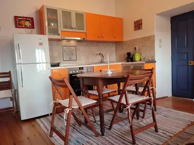 a kitchen with a table and chairs and a refrigerator at Omorfo House in Asklipiḯon