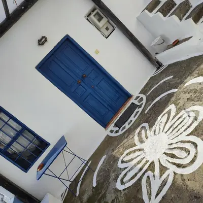 a blue door on the side of a white building at Omorfo House in Asklipiḯon