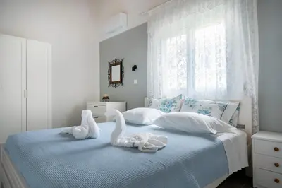 two swans sitting on a bed in a bedroom at CASA DI'ELEN in Faliraki