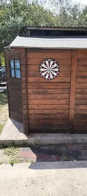 a wooden garage with a dart board on it at Green Heaven in Koskinou