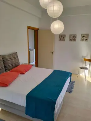 a bedroom with a large bed with blue and red pillows at Green Heaven in Koskinou
